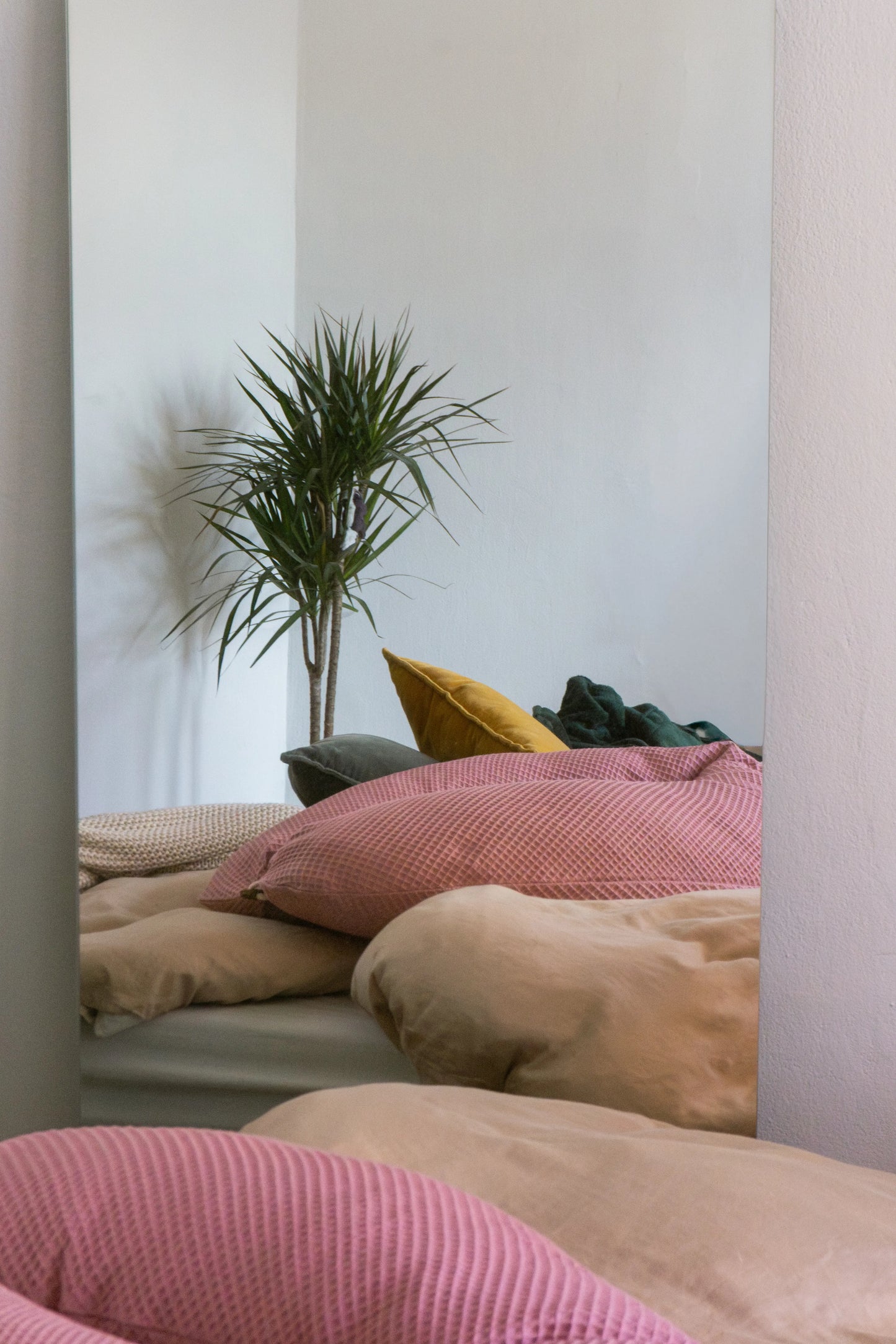 rosafarbenes Stillkissen liegt auf gemütlichem Bett