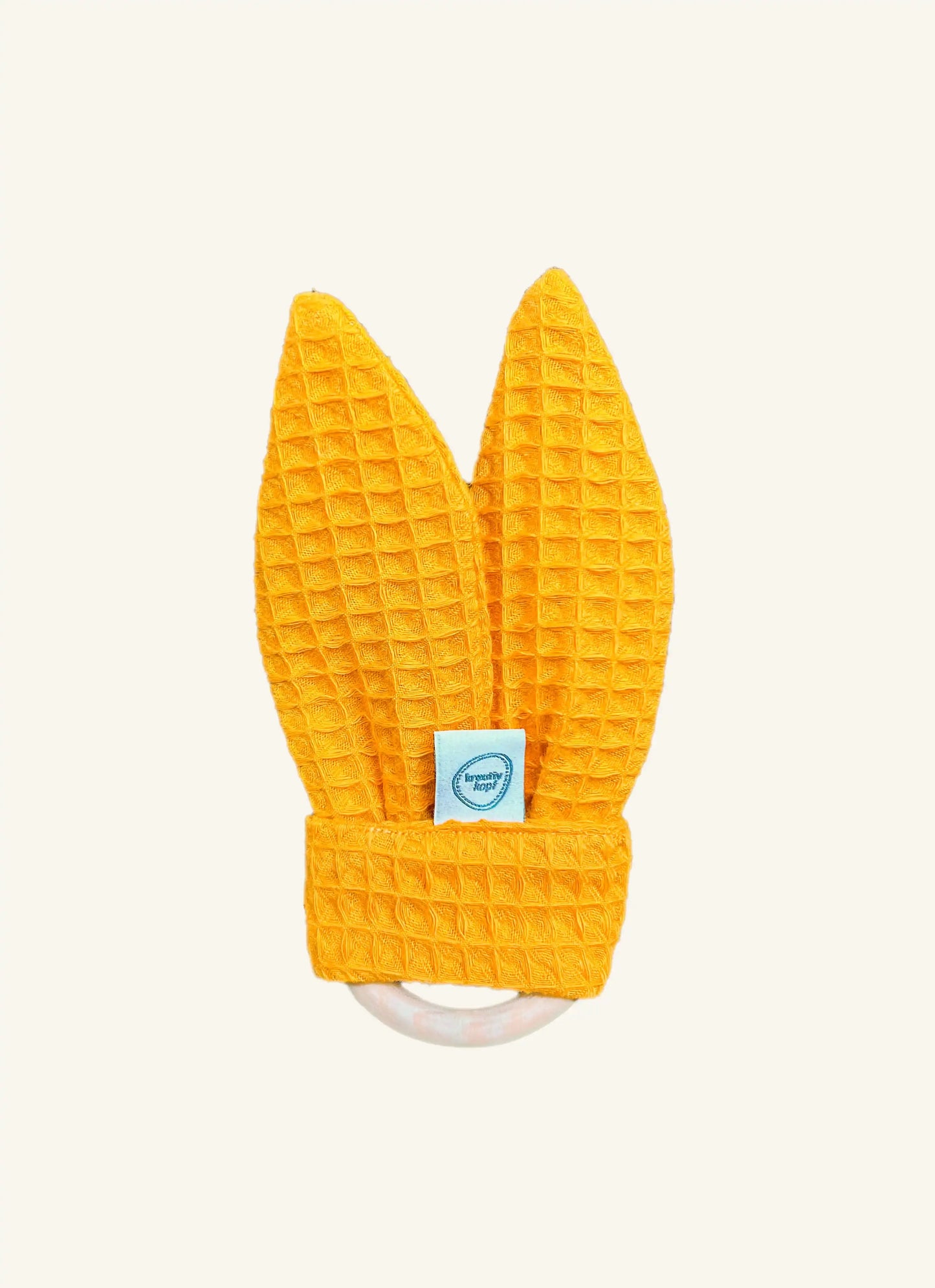 Beißring für zahnende Babys aus Zirbenholz mit Hasenohren aus gelbem Waffelstoff und Knisterpapier