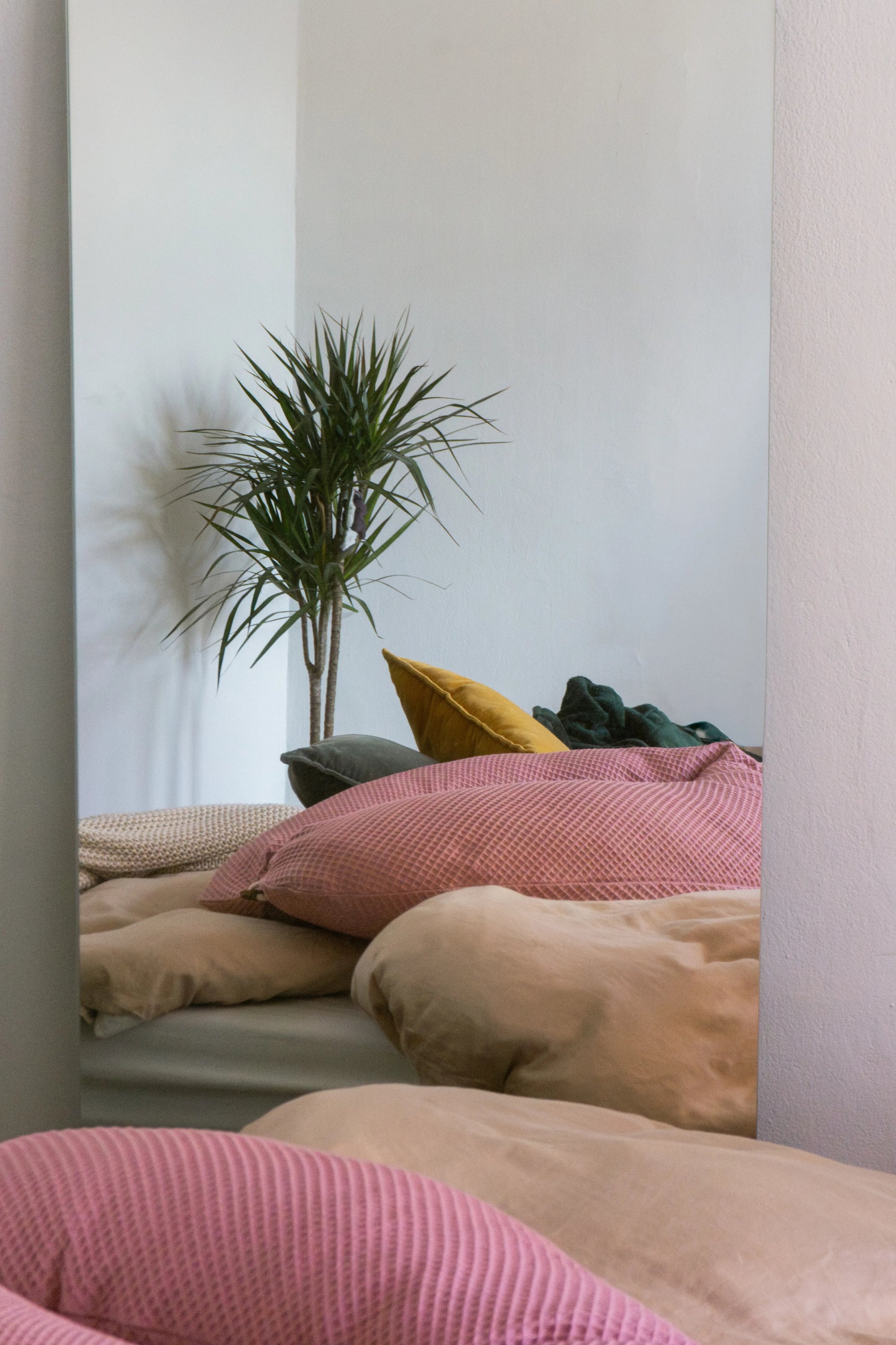 rosafarbenes Stillkissen liegt auf gemütlichem Bett