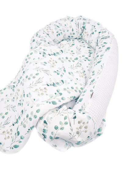 Zweifarbiges Babynest: der eine Stoff ist glatt mit einem Eukalyptus Muster, der andere ist ein weißer Waffelstoff