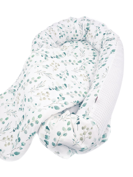Zweifarbiges Babynest: der eine Stoff ist glatt mit einem Eukalyptus Muster, der andere ist ein weißer Waffelstoff