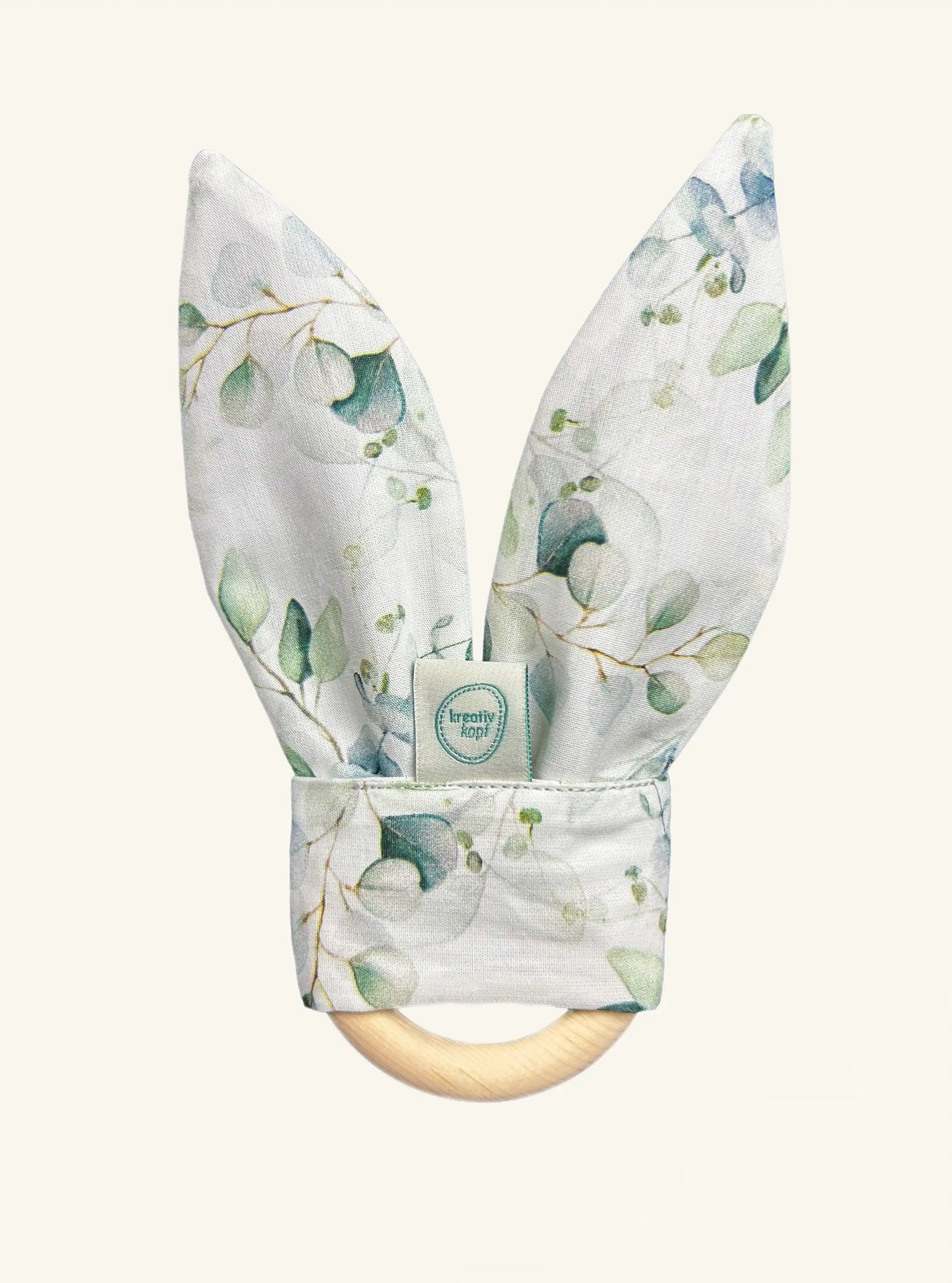 Beißring für zahnende Babys aus Zirbenholz mit Hasenohren aus glattem weißen Stoff mit Eukalyptus Muster und Knisterpapier