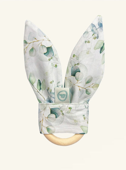 Beißring für zahnende Babys aus Zirbenholz mit Hasenohren aus glattem weißen Stoff mit Eukalyptus Muster und Knisterpapier